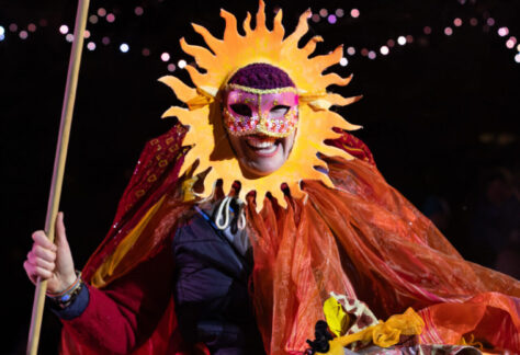 A performer circles the bonfire in their hand-made costume